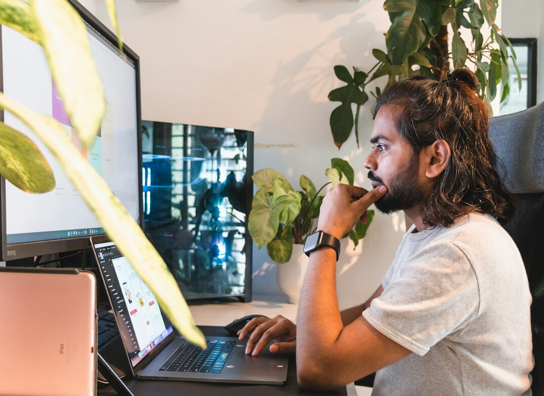 young man coding on laptop